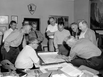 Conrad Wirth (seated with glasses) examining Mission 66 plans for Yosemite in 1956