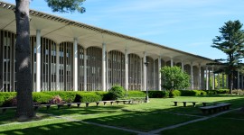 Building with long colonnade, plants and paths in front